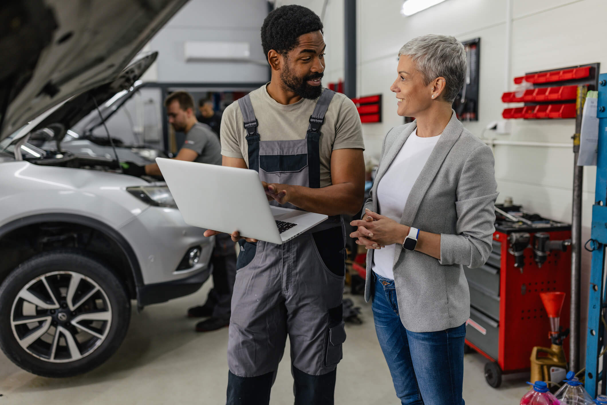 Automotive technician showing laptop to customer